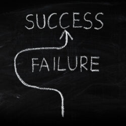 The words "success" and "failure" written on a chalkboard with an arrow pointing towards "success"