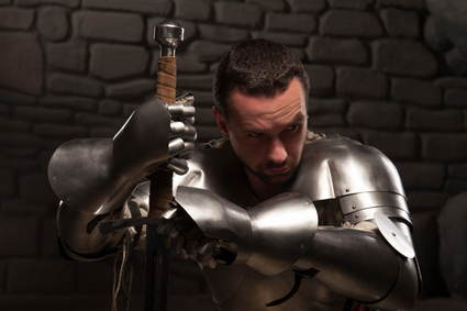 Medieval knight kneeling with sword
