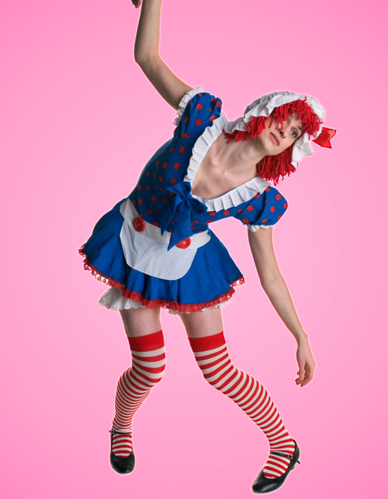 Photo of a thin feminine person with light skin wearing a rag doll costume