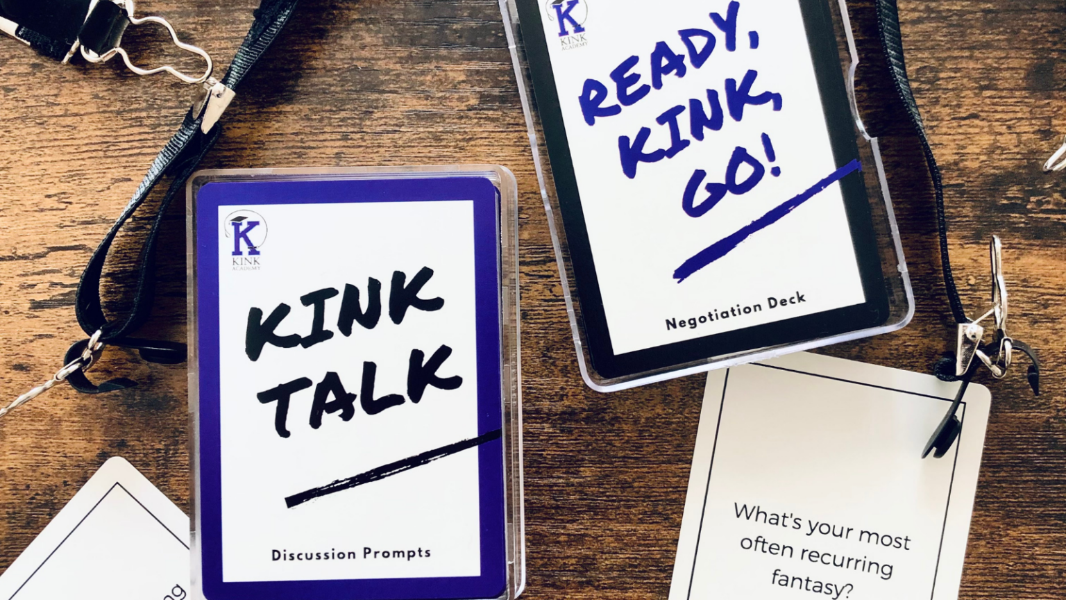 Kink Talk and Ready, Kink, Go! card games on a brown wood table
