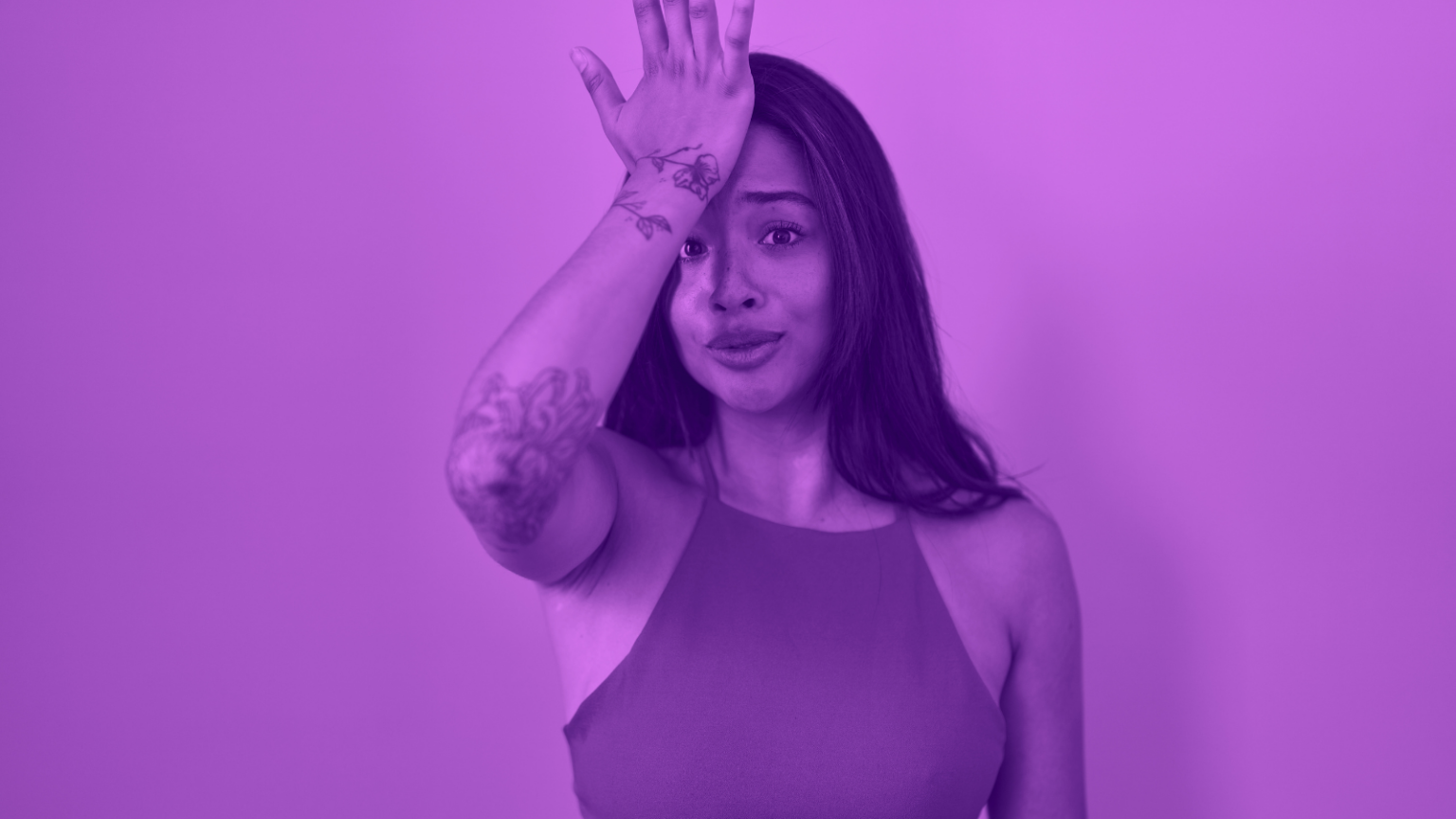 Purple photo of a feminine person in a tank top making an "oops" face with their palm on their forehead