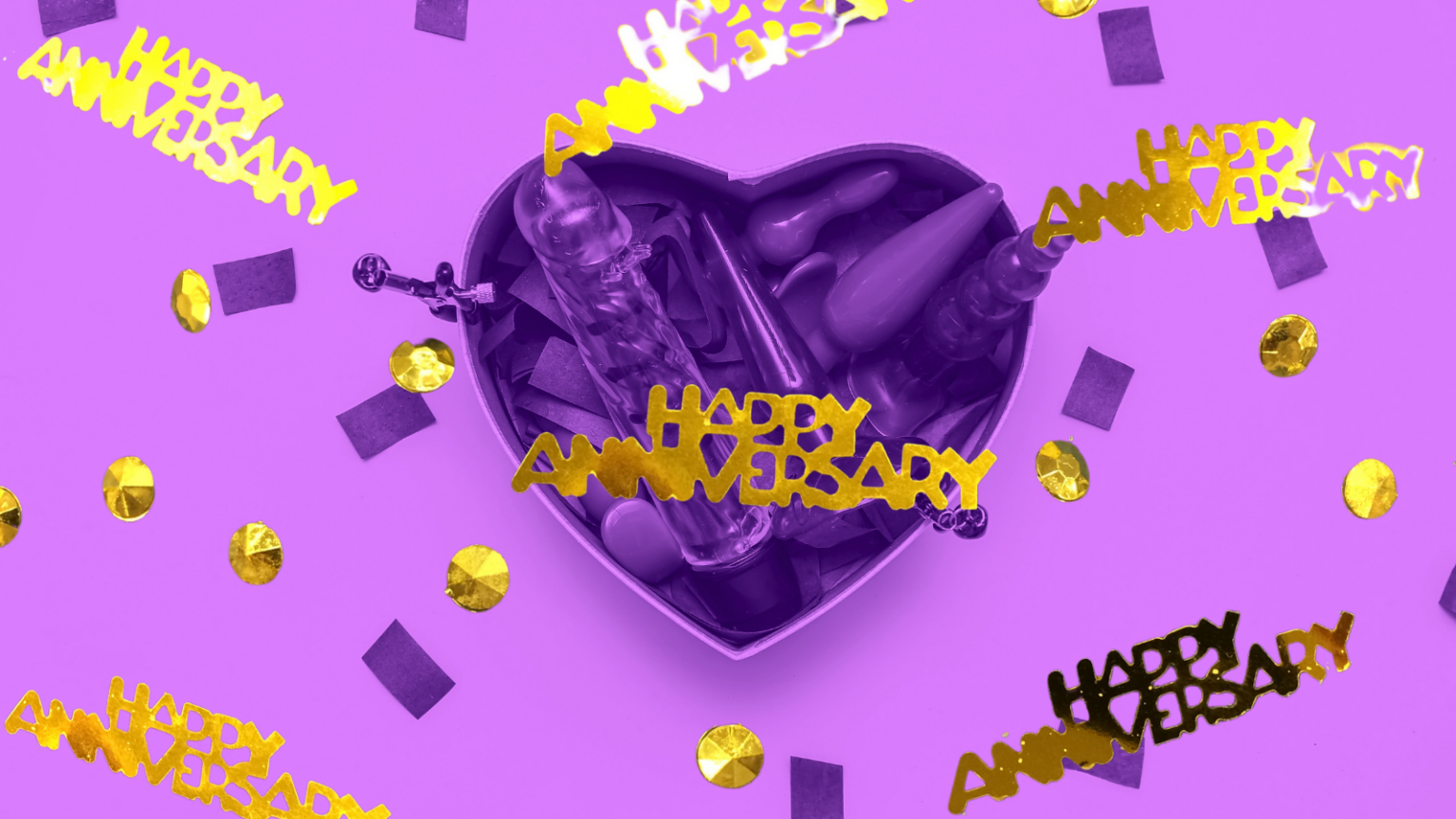 Photo of a heart shaped box of sex toys with "Happy Anniversary" confetti