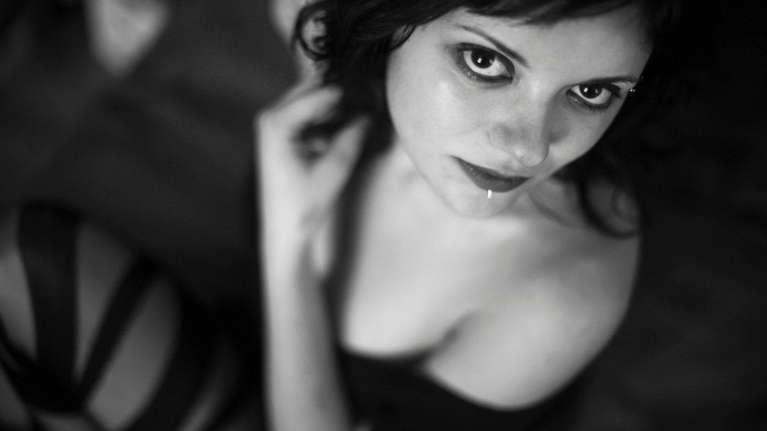 Black and white photo of a plus size feminine person looking at the camera with a somber expression