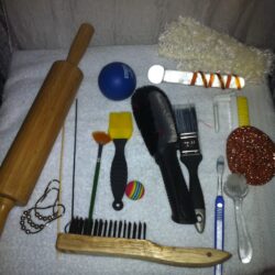 A rolling pin and other household objects laid out on a towel